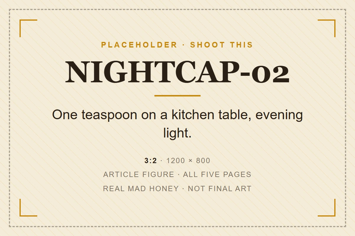 A teaspoon of dark mad honey beside an open jar on a kitchen table in evening light