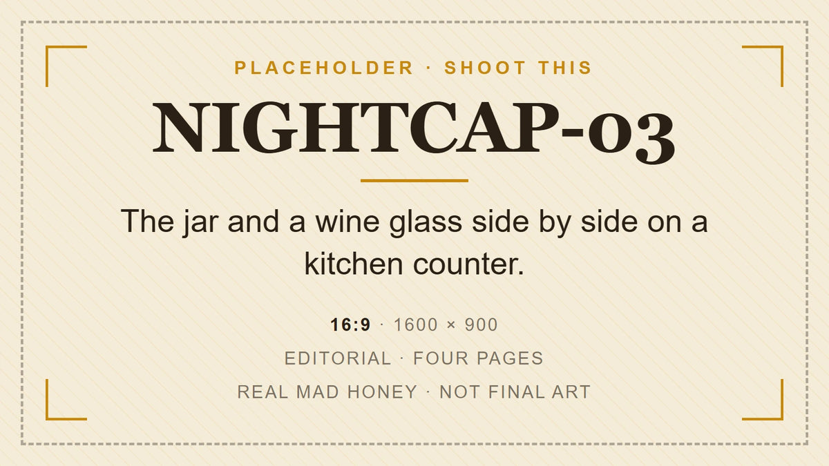 An open jar of mad honey with a teaspoon next to an empty wine glass on a kitchen counter
