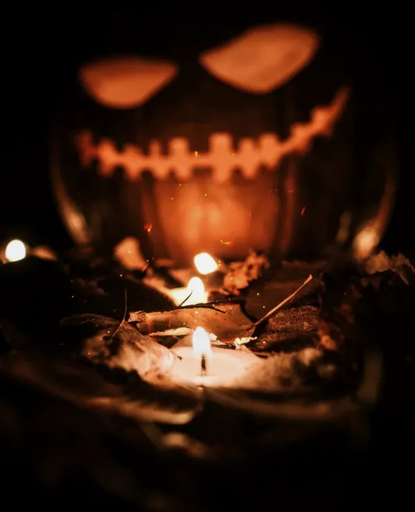 Glowing carved pumpkin over a candle