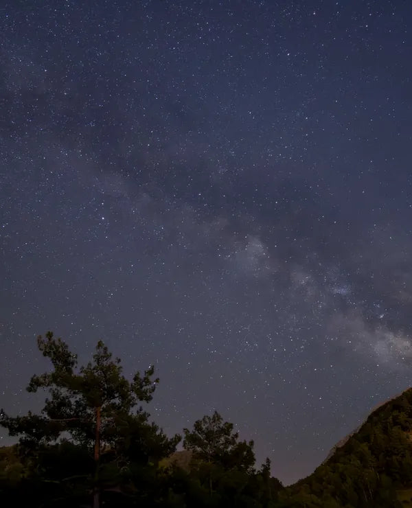 Starry night sky over quiet mountains