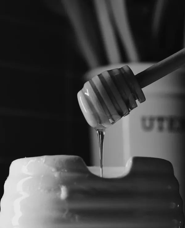 Honey dipper resting in a jar of honey