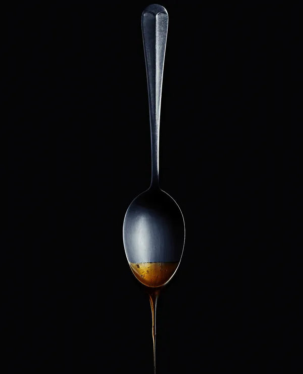 Spoon with a drop of golden honey